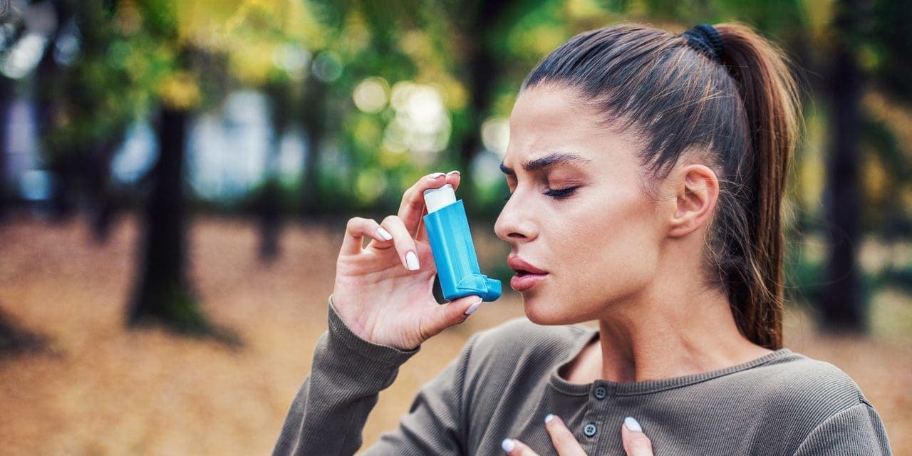 woman using asthma inhaler